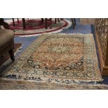 FINELY KNOTTED KIRMAN RUG, with star shaped centre medallion with pendants on a pink field scattered