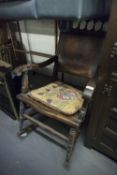 A LATE VICTORIAN/EDWARDIAN BEECHWOOD ROCKING CHAIR WITH WOODEN PANEL BACK AND SEAT