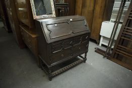 A TWENTIETH CENTURY OAK BUREAU FALL-FRONT WITH FITTED COMPARTMENTS OVER TWO SHORT AND ONE LONG