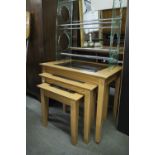 A NEST OF THREE LIGHT OAK OBLONG COFFEE TABLES, WITH INSET PLATE GLASS TOPS