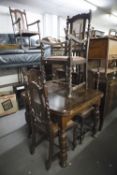 AN EARLY TWENTIETH CENTURY OAK DRAW LEAF DINING TABLE TOGETHER WITH A MATCHED SET OF FIVE (3+2) CANE