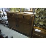 AN OAK SIDEBOARD WITH TWO DRAWERS OVER A CUPBOARD WITH TWO DOORS