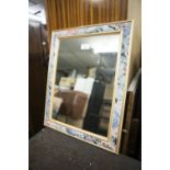AN OBLONG WALL MIRROR, IN LEAF DECORATED FRAME