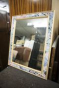 AN OBLONG WALL MIRROR, IN LEAF DECORATED FRAME