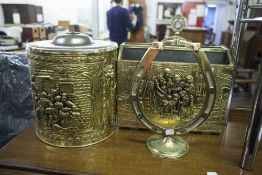 AN EMBOSSED BRASS CLAD PERIODICAL RACK, AN EMBOSSED BRASS CYLINDRICAL COAL RECEIVER AND A BRASS