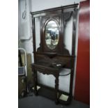 A VICTORIAN MAHOGANY HALL STAND, THE CENTRAL OVAL MIRROR OVER SHELF, CARVED DECORATION THROUGHOUT,