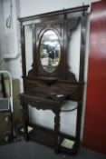 A VICTORIAN MAHOGANY HALL STAND, THE CENTRAL OVAL MIRROR OVER SHELF, CARVED DECORATION THROUGHOUT,