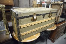 A WOODEN AND LEATHERETTE COVERED TRAVELLING TRUNK