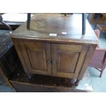 AN OAK SMALL SQUARE CUPBOARD/COFFEE TABLE AND AN EBONISED CIRCULAR OCCASIONAL TABLE WITH UNDER