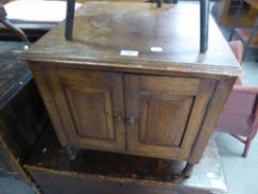AN OAK SMALL SQUARE CUPBOARD/COFFEE TABLE AND AN EBONISED CIRCULAR OCCASIONAL TABLE WITH UNDER