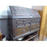 A TWENTIETH CENTURY OAK BUREAU FALL-FRONT WITH FITTED COMPARTMENTS OVER TWO SHORT AND ONE LONG