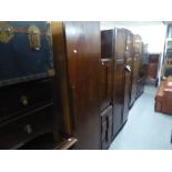 A PAIR OF ART DECO OAK BEDSIDE TABLES OF FOUR GRADUATED DRAWERS AND A MATCHING WARDROBE (3)