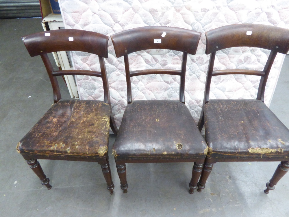 A SET OF THREE EARLY NINETEENTH CENTURY MAHOGANY DINING CHAIRS, WITH CURVED SHOULDER BOARDS, ON