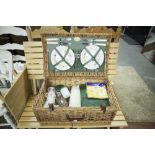 A WICKER PICNIC HAMPER FITTED WITH CONTENTS, FOR FOUR PERSONS AND A COLLAPSIBLE PICNIC TABLE AND TWO