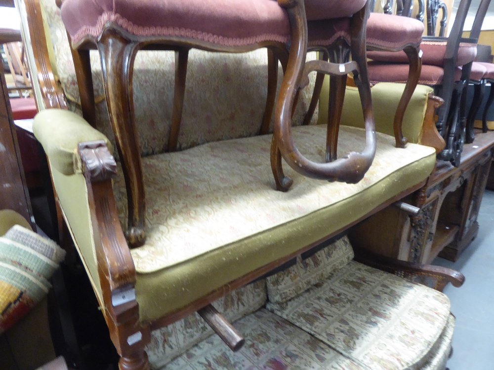 AN EARLY TWENTIETH CENTURY CARVED WALNUTWOOD FRAMED WINGED DRAWING ROOM SETTEE, ON TURNED FRONT