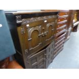 JACOBEAN STYLE CARVED OAK FOUR DOOR COCKTAIL CABINET WITH PULL-OUT GLASS INSET SLIDE AND COCK'S HEAD