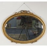 REGENCY STYLE OVAL GILT GESSO WALL MIRROR, the bevel edged plate in a moulded frame with ribbon tied