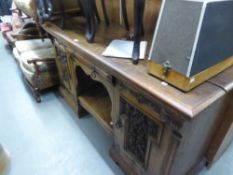 A LATE VICTORIAN CARVED OAK PEDESTAL SIDEBOARD, WITH CENTRE DRAWER OVER AN AN OPEN COMPARTMENT,