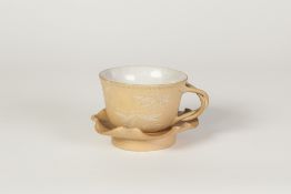 A CHINESE YIXING TYPE CUP AND SAUCER, the cup with cracked glazed interior, the buff biscuit