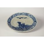 A LATE NINETEENTH CENTURY CHINESE CRACKLE WARE SHALLOW DISH, painted in underglaze blue with a