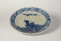 A LATE NINETEENTH CENTURY CHINESE CRACKLE WARE SHALLOW DISH, painted in underglaze blue with a