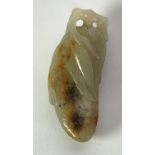 A CHINESE QING DYNASTY CELADON JADE CARVING with russet inclusions in the form of a pumpkin