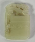 A CHINESE QING DYNASTY PALE CELADON JADE CARVING in the form of a archaistic flattened axe and