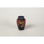 WILLIAM MOORCROFT POMEGRANATE PATTERN TUBE LINED POTTERY SMALL VASE, of ovoid form, decorated in