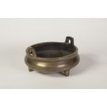 CHINESE BRASS TWO HANDLED SHALLOW POT, on three short tapering supports, 3 1/4" (8.3cm) high, 6" (