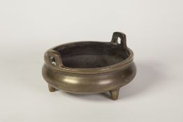 CHINESE BRASS TWO HANDLED SHALLOW POT, on three short tapering supports, 3 1/4" (8.3cm) high, 6" (