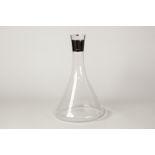 A MODERN CLEAR GLASS DECANTER OF SPREADING TAPERED DESIGN with glass stopper, the neck with plain