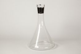 A MODERN CLEAR GLASS DECANTER OF SPREADING TAPERED DESIGN with glass stopper, the neck with plain