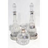 A PAIR OF CUT GLASS TALL SKITTLE SHAPED DECANTERS, with silver necks and fluted tear shaped