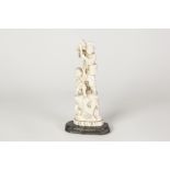 JAPANESE MEIJI PERIOD CARVED ONE PIECE IVORY GROUP, of a man standing on a high rock playing a