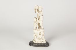 JAPANESE MEIJI PERIOD CARVED ONE PIECE IVORY GROUP, of a man standing on a high rock playing a