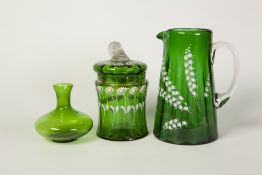TWO PIECES OF VICTORIAN GREEN GLASS, enamelled with flowers, comprising a TAPERING JUG, 7 1/4" (18.
