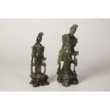 TWO LATE NINETEENTH/EARLY TWENTIETH CENTURY CHINESE GREEN SOAPSTONE FEMALE FIGURES, one holding a