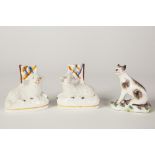 A PAIR OF VICTORIAN STAFFORDSHIRE POTTERY MINIATURE MODELS OF RECUMBENT LAMBS, each with a flag,