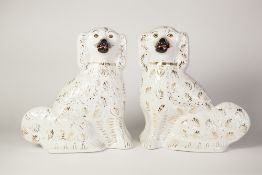 A PAIR OF VICTORIAN STAFFORDSHIRE POTTERY MANTEL SHELF DOGS, gilt decorated with black muzzles