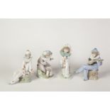 FOUR NAO, SPANISH PORCELAIN FIGURES OF YOUNG CLOWNS, three modelled seated, including one with a