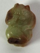 CHINESE QING DYNASTY TINY CELADON JADE CARVING with russet inclusions of a bear, pierced through for
