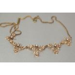 EDWARDIAN GOLD COLOURED (UNMARKED) FINE ROPE CHAIN NECKLACE, the five part stiff front floral and