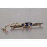 EDWARDIAN 9ct GOLD BAR BROOCH, the pointed oblong centre set with three round sapphires and two