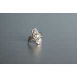 ART DECO PERIOD PLATINUM AND DIAMOND RING, cross set with three round transitional cut diamonds, the