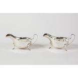 PAIR OF SILVER SAUCE BOATS, each oval with cyma edge, with raised 'C' scroll handle, on three pad