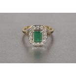 18ct GOLD, EMERALD AND DIAMOND CLUSTER RING, with a collet set oblong centre emerald, approx 8mm x