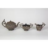 AN EARLY TWENTIETH CENTURY INDIAN METAL THREE PIECE TEA SERVICE, embossed with leafage, marked R.