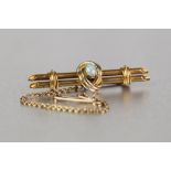 AN EDWARDIAN 15ct GOLD DOUBLE BAR BROOCH, centrally set with an opal with safety chain, 5.1gms gross