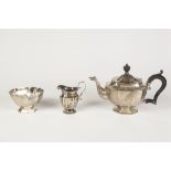 A LATE VICTORIAN SILVER COMPOSITE THREE PIECE TEA SERVICE, each of panelled form, the TEAPOT with