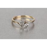 A 18ct YELLOW GOLD AND PLATINUM TWO STONE DIAMOND SET CROSSOVER RING, each 0.20ct